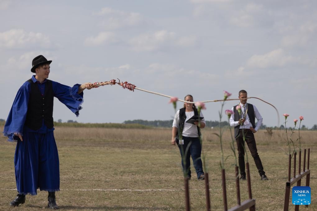 A participant tries to cut a flower with a whip during a traditional herdsmen competition in Hortobagy, Hungary, on Sept. 13, 2025. (Photo: Xinhua)