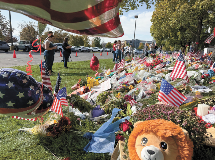 People bring flowers and write messages in chalk at a memorial for Charlie Kirk at Utah Valley University, in Orem, Utah, on September 15, 2025. Photo: VCG