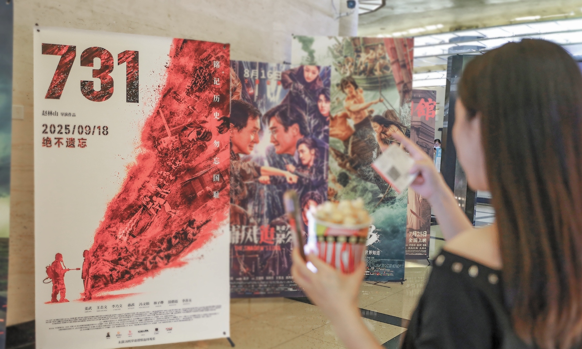 A viewer stands in front of the poster of the Chinese film 'Evil Unbound' Photo: VCG
