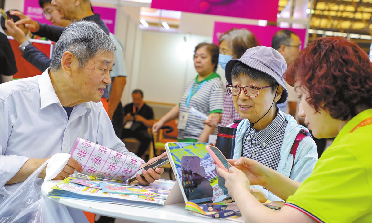 Senior citizens consult a tourism brochure at the International Exhibition of Senior Care, Rehabilitation Medicine and Healthcare Shanghai 2025, on June 11, 2025. Photo: VCG