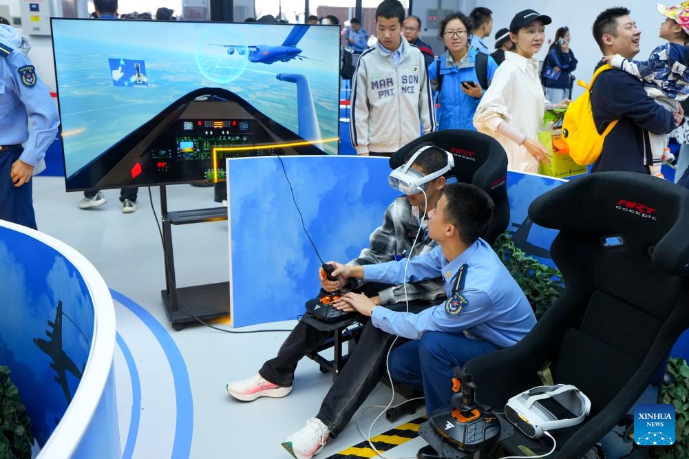 A kid experiences aircraft flight simulation during the 2025 aviation open-day activities of the Chinese People's Liberation Army (PLA) Air Force and Changchun Air Show in Changchun, northeast China's Jilin Province, Sept. 20, 2025. The event is held here from Sept. 19 to 23, which comprehensively showcases the history and modernization of the PLA Air Force through aerobatic performances, equipment exhibitions, and various interactive activities. (Photo: Xinhua)