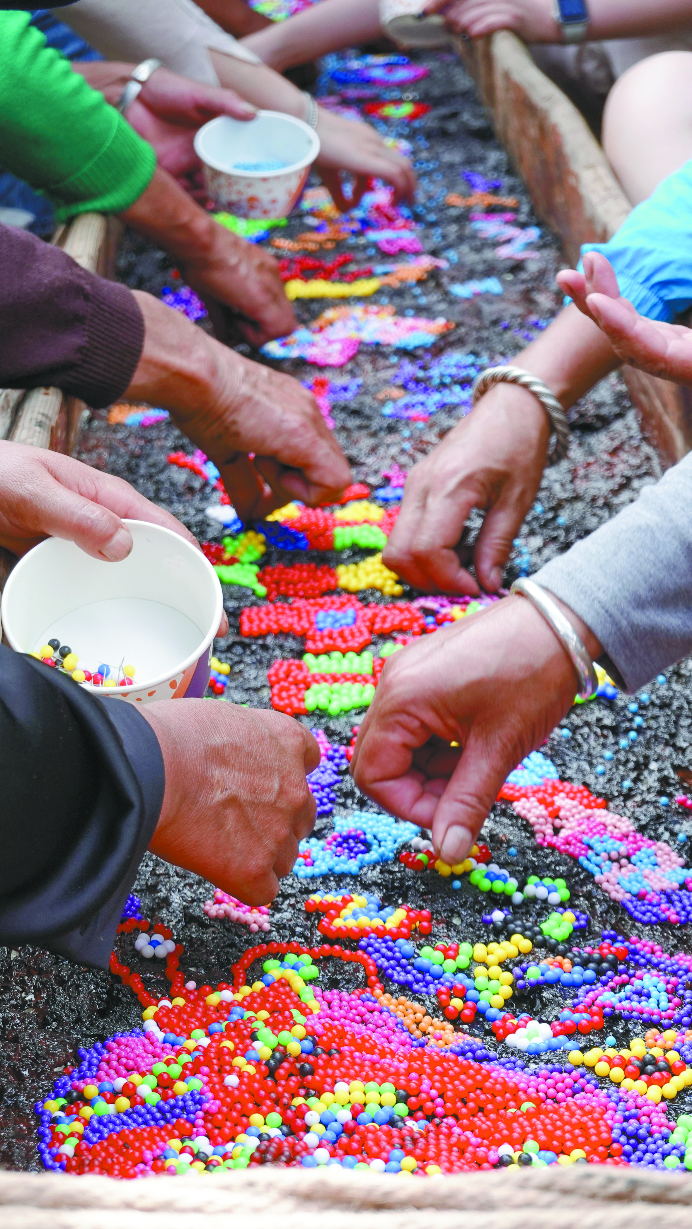 Local women co-creators stitch patterns onto a boat-shaped installation called La barca leggera. Photo: Courtesy of MOWA