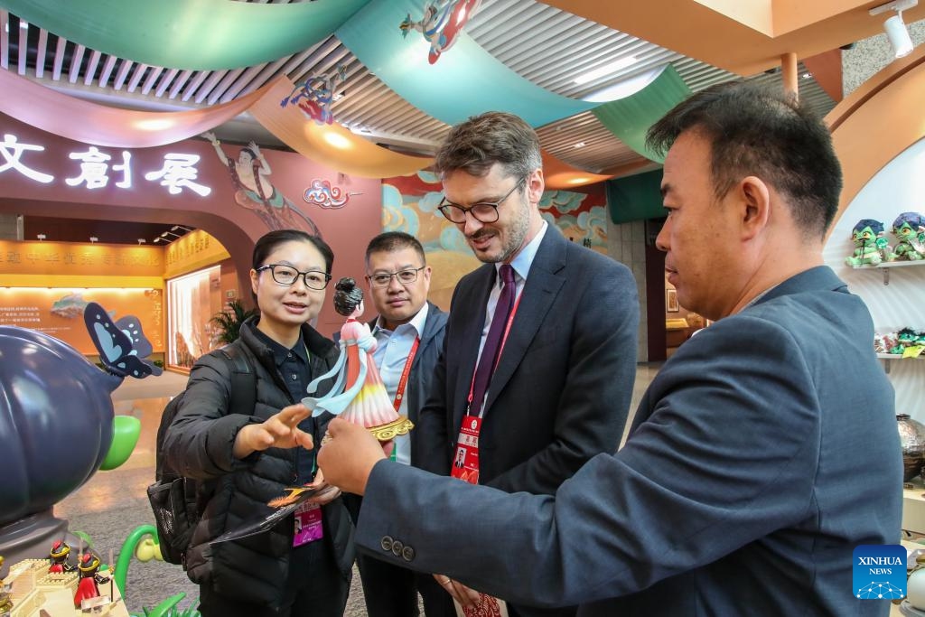 Guests learn about a cultural and creative product produced with 3D printing technology during the 8th Silk Road (Dunhuang) International Cultural Expo in Dunhuang, northwest China's Gansu Province, Sept. 21, 2025. More than 1,200 representatives from 97 countries and eight international organizations have gathered at the 8th Silk Road (Dunhuang) International Cultural Expo, which kicked off on Sunday in Dunhuang, a key hub on the ancient Silk Road in northwest China. (Photo: Xinhua)