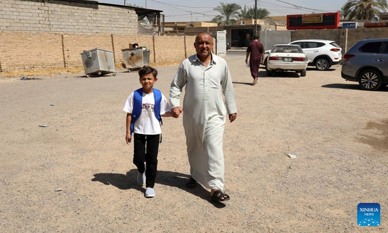 A boy goes to school accompanied by his father in Baghdad, Iraq, on Sept. 21, 2025. The new academic school year started on Sunday in Iraq. (Photo: Xinhua)