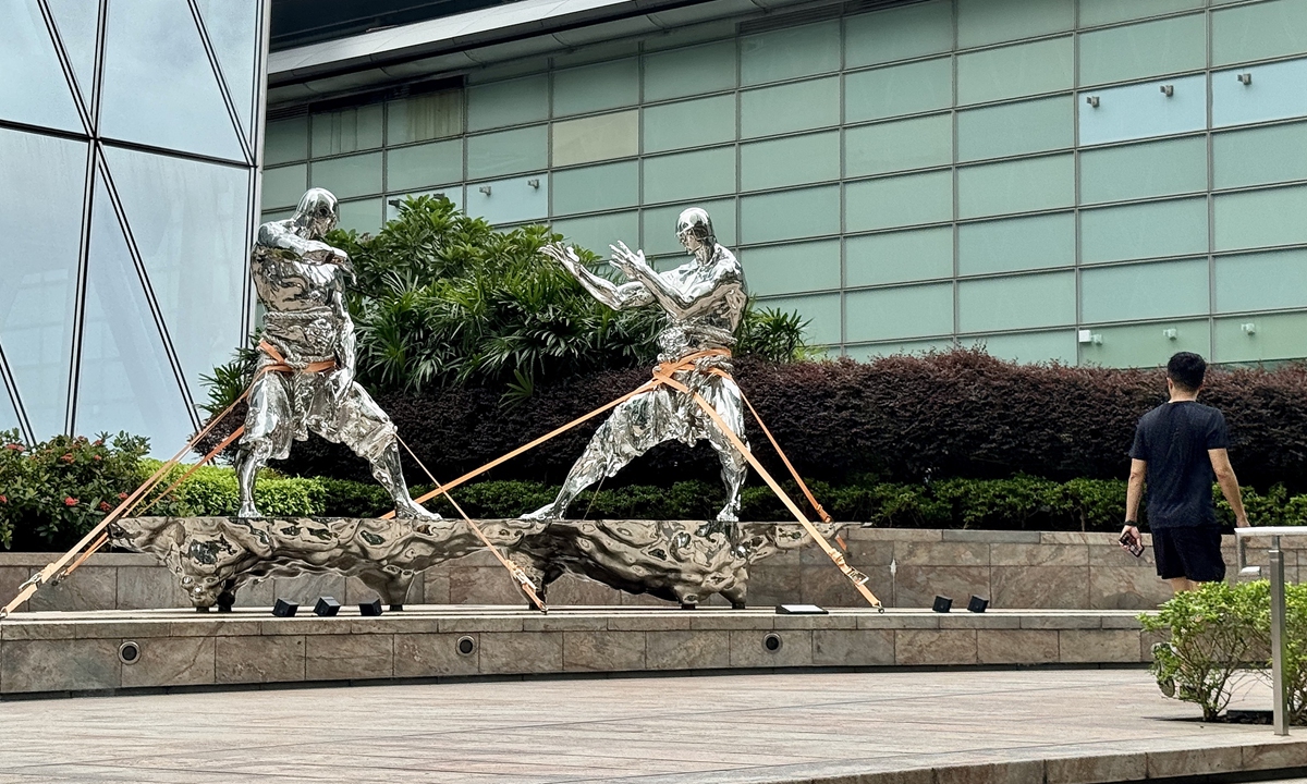 A man walks past statues that have been secured against strong winds from Super Typhoon Ragasa in Exchange Square in Hong Kong on September 23, 2025. The typhoon is forecast to make landfall along Guangdong Province's coastal areas on September 24. Photo: VCG