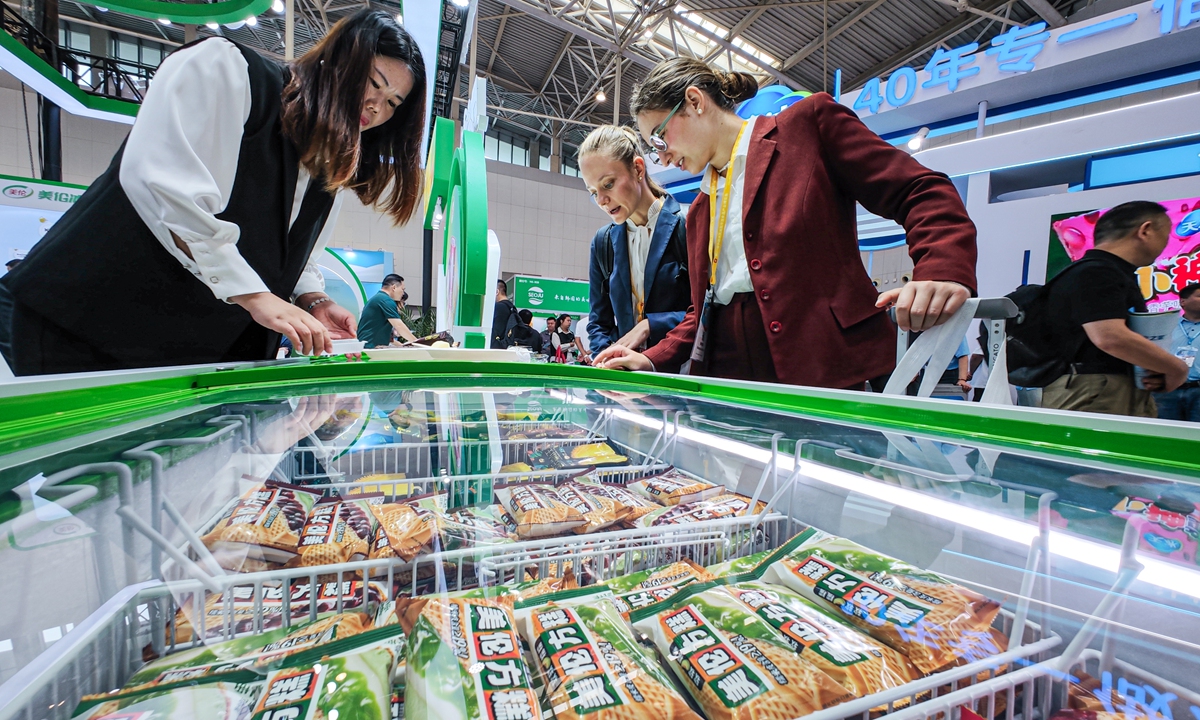 Overseas buyers observe Chinese ice cream products at an ice cream and frozen food industry expo in North China's Tianjin Municipality on September 24, 2025. The exhibition attracted more than 500 companies from China, Russia, Belarus, Italy, Belgium, Germany, New Zealand and other countries and regions, showcasing the latest ice cream products. Photo: cnsphoto