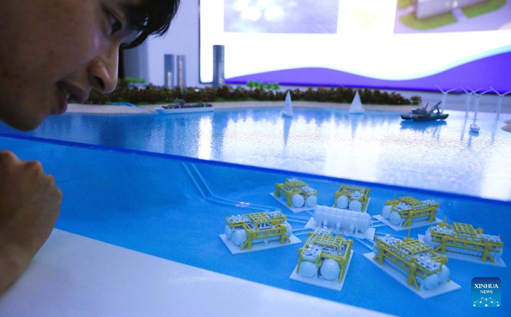 A visitor observes a miniature model of undersea data cabins for an undersea data center, in Lingshui, south China's Hainan Province, Sept. 25, 2025.