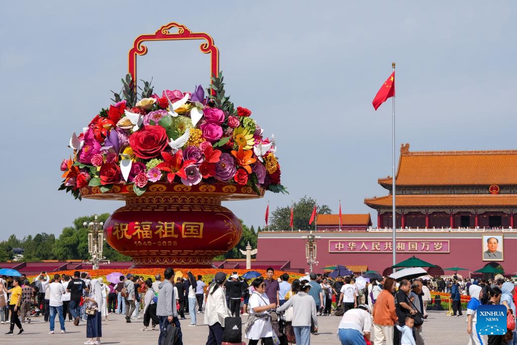 Tourists view a flower basket installation at Tian'anmen Square in Beijing, capital of China, Sept. 25, 2025. The 18-meter-high installation in the shape of a flower basket is placed at Tian'anmen Square as a decoration for the upcoming National Day holiday. (Xinhua/Ju Huanzong)