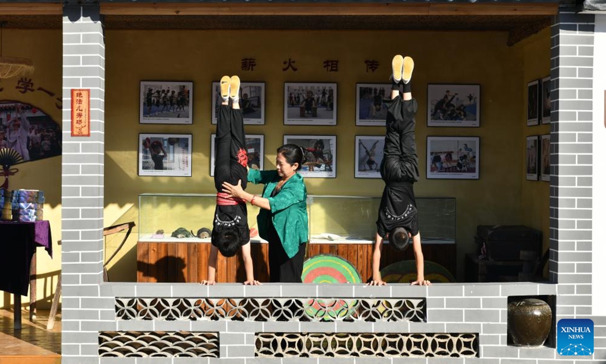 Students practice acrobatic skills under the instruction of Diao Guihua (C) at the Diao's Troupe acrobatic courtyard in Sangyuan Town, Wuqiao County, north China's Hebei Province, on Sept. 25, 2025. Wuqiao, dubbed the cradle of Chinese acrobatic art, boasts 14 diverse acrobatic courtyards that serve as a cluster of bases for artist training, new play designing, and folk art research. (Xinhua/Mu Yu)