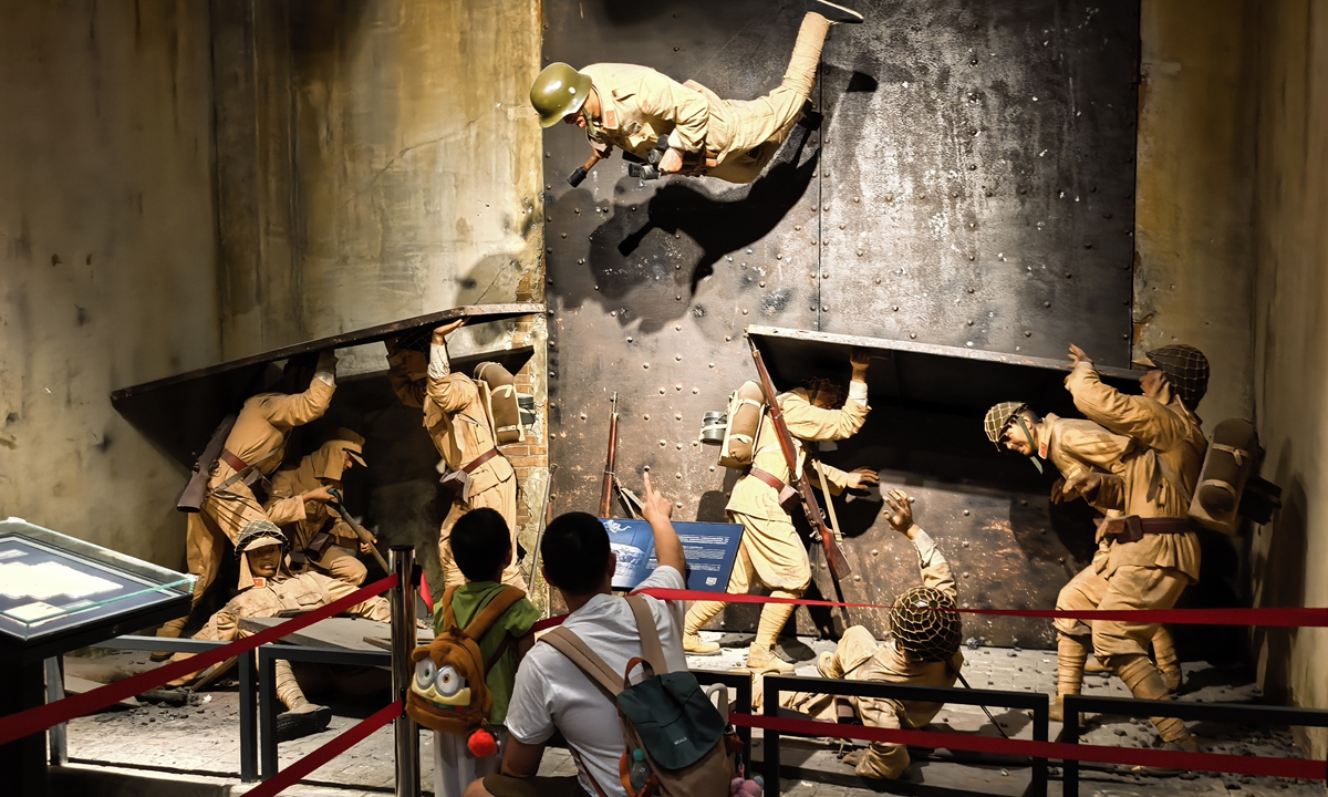 A father shares the story of the Chinese blockbuster <em>The Eight Hundred</em> with his son at the Shanghai Sihang Warehouse Battle Memorial in Shanghai, September 26, 2025. Released in 2020, the film portrays the historical defense of Sihang Warehouse by Chinese soldiers against the invading Japanese army during the Battle of Shanghai in 1937. Photo: Liu Yang/GT