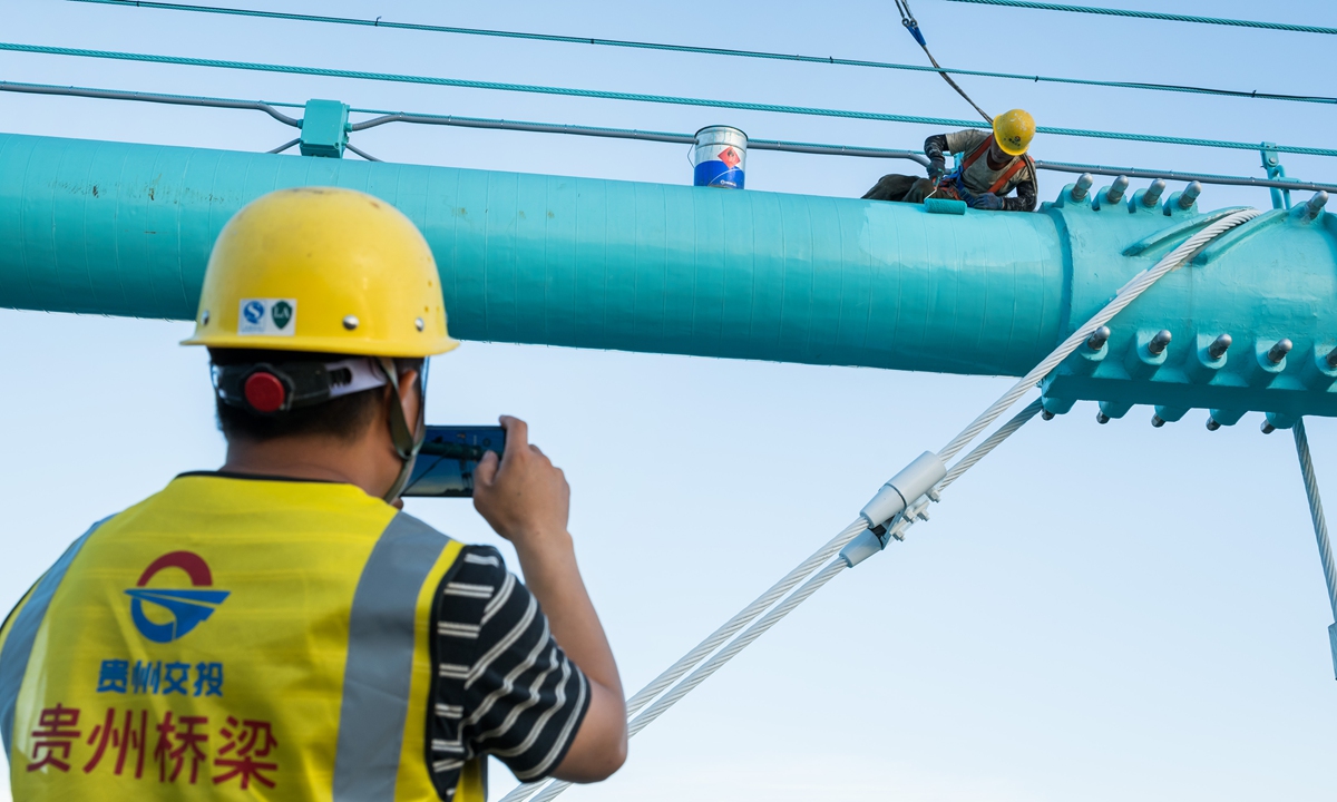 Construction workers from Guizhou Communications Investment Group Corporation carry out painting work on the bridge on September 24, 2025. Photo: Chen Tao/GT