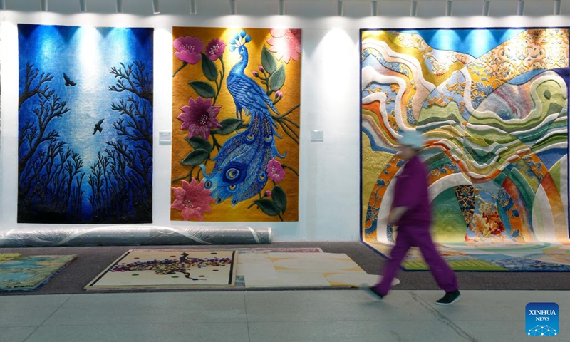 An employee walks past Tibetan carpets displayed at a workshop of Shengyuan carpet group in Xining, northwest China's Qinghai Province, Sept. 27, 2025. Tibetan carpet is a traditional handicraft on the Qinghai-Tibetan Plateau with a history of more than 1,000 years. The carpets are essential items for the nomadic people on the plateau to withstand the cold. The fine yak and sheep wool and the delicate weaving skills and patterns made the handmade products popular among overseas and domestic customers. (Photo: Xinhua)