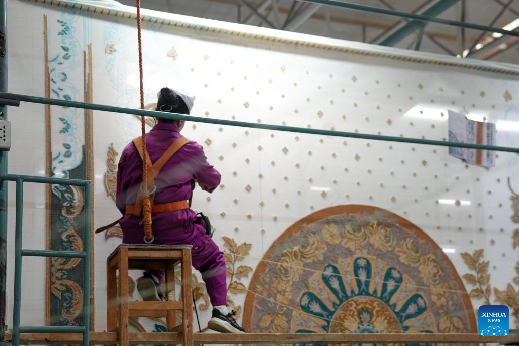 An employee works on a Tibetan carpet at a workshop of Shengyuan carpet group in Xining, northwest China's Qinghai Province, Sept. 27, 2025. Tibetan carpet is a traditional handicraft on the Qinghai-Tibetan Plateau with a history of more than 1,000 years. The carpets are essential items for the nomadic people on the plateau to withstand the cold. The fine yak and sheep wool and the delicate weaving skills and patterns made the handmade products popular among overseas and domestic customers. (Photo: Xinhua)