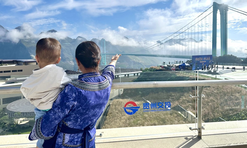 Lu Qiong, a resident of the Buyi ethnic group, and her young son look at the Huajiang Grand Canyon Bridge from an adjacent service area in Southwest China’s Guizhou Province on September 28, 2025. Photo: Lin Xiaoyi/GT