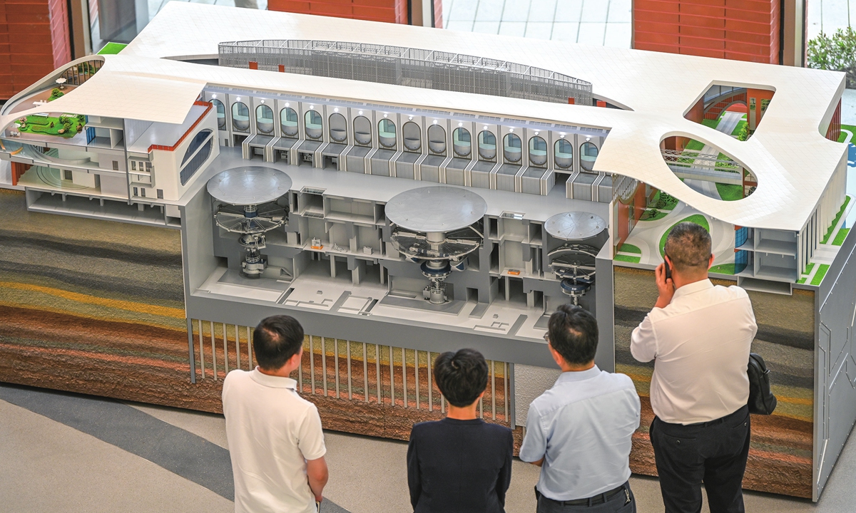 Visitors view a model of China's super-gravity centrifuge simulation and experiment facility in Hangzhou, East China's Zhejiang Province on September 29, 2025. The facility houses the world's largest centrifuge, capable of generating a 