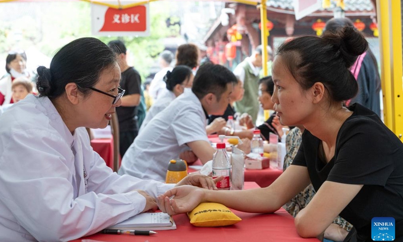 Citizens experience free diagnosis and treatment services at the Traditional Chinese Medicine (TCM) Street in Bishan District, southwest China's Chongqing Municipality, Sept. 30, 2025. The Traditional Chinese Medicine Street, a cultural block featuring traditional Chinese medicine, opened to public on Tuesday. Characteristic cultural fairs, free TCM clinics, and Qigong performances will be held here during the upcoming National Day holiday and the Mid-Autumn Festival. (Xinhua/Chen Cheng)