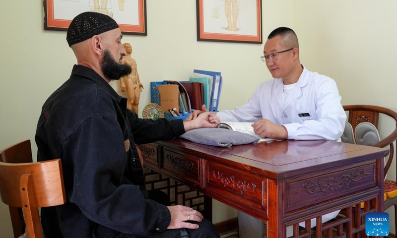 A doctor takes the pulse of a Russian patient at a hospital in Hunchun, northeast China's Jilin Province, Sept. 29, 2025.