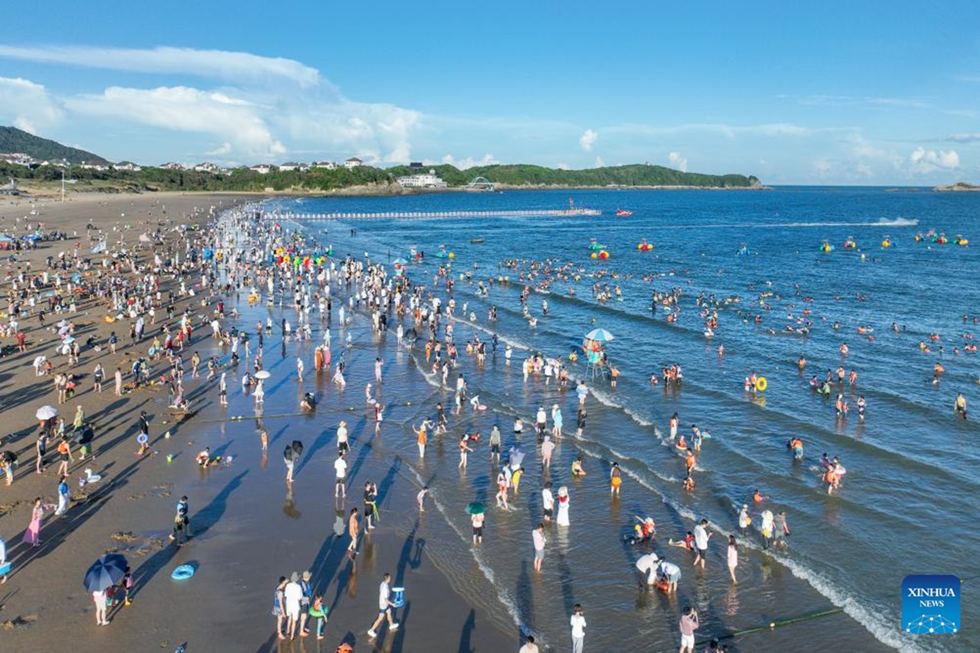 An aerial drone photo taken on Oct. 2, 2025 shows tourists having fun on a beach in Zhoushan, east China's Zhejiang Province. Tourist destinations across China are witnessing a surge in visitors as the country's eight-day National Day and Mid-Autumn Festival holiday began on Wednesday. (Photo by Zou Xunyong/Xinhua)

