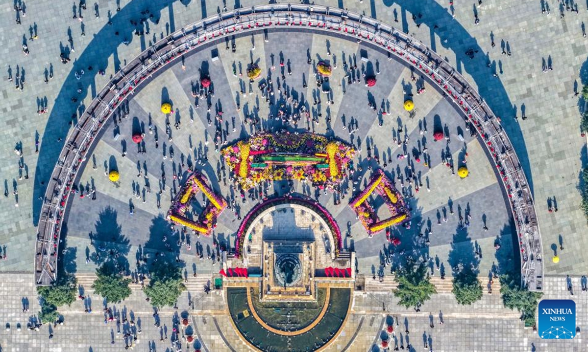 An aerial drone photo taken on Oct. 2, 2025 shows tourists visiting the square of the Flood Control Monument in Harbin, northeast China's Heilongjiang Province. With China's Mid-Autumn Festival falling alongside National Day this year, people spend their leisure time through various ways during the eight-day holiday. (Photo by Chen Nan/Xinhua)

