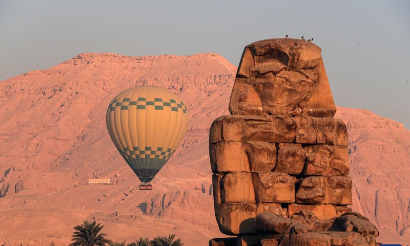 A hot air balloon is pictured near the Colossi of Memnon on the west bank of Nile River in Luxor, Egypt, on Oct. 4, 2025. Luxor, a capital of ancient Upper Egypt known as Thebes, is a tourist destination famous for the historic temple buildings and other relics. Nowadays taking hot air balloon trips is a popular choice for tourists visiting Luxor. (Xinhua/Ahmed Gomaa)