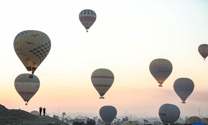 A hot air balloon is pictured near the Colossi of Memnon on the west bank of Nile River in Luxor, Egypt, on Oct. 4, 2025. Luxor, a capital of ancient Upper Egypt known as Thebes, is a tourist destination famous for the historic temple buildings and other relics. Nowadays taking hot air balloon trips is a popular choice for tourists visiting Luxor. (Xinhua/Ahmed Gomaa)
