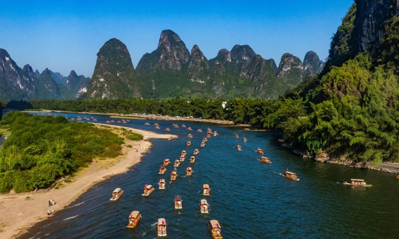 An aerial drone photo taken on Oct. 3, 2025 shows tourists enjoying a molten iron fireworks show at a scenic area in Tancheng County of Linyi City, east China's Shandong Province. Tourist destinations across China are witnessing a surge in visitors as the country's eight-day National Day and Mid-Autumn Festival holiday began on Wednesday. (Photo by Zhang Chunlei/Xinhua)