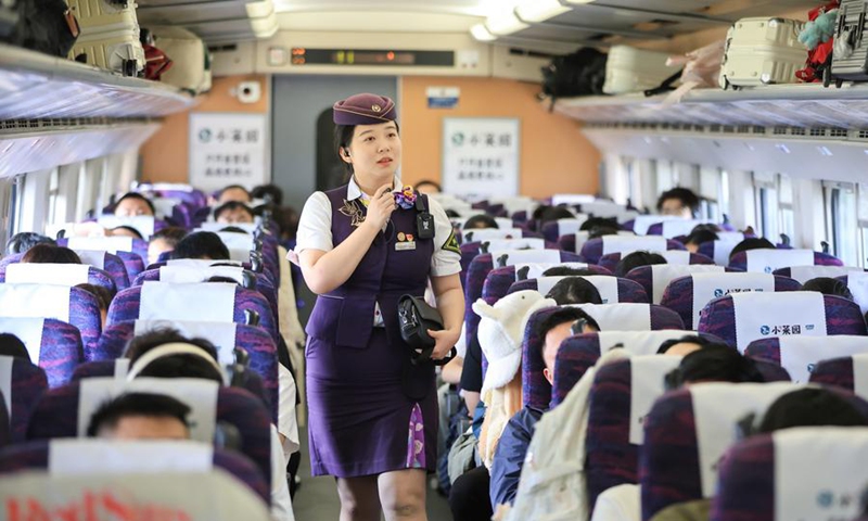 A train attendant works on a train in east China's Jiangsu Province, Oct. 1, 2025. (Photo by Su Yang/Xinhua)