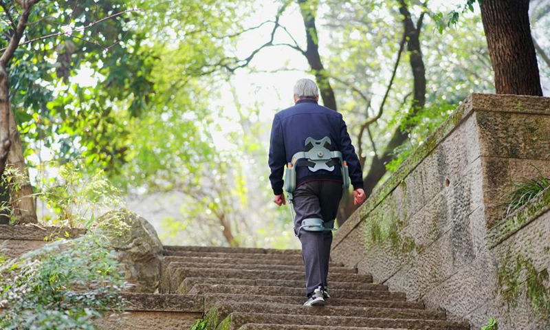 A senior citizen wearing an exoskeleton walking aid device climbs the stairs in Hangzhou, east China's Zhejiang Province, Feb. 24, 2025. (RoboCT/Handout via Xinhua)