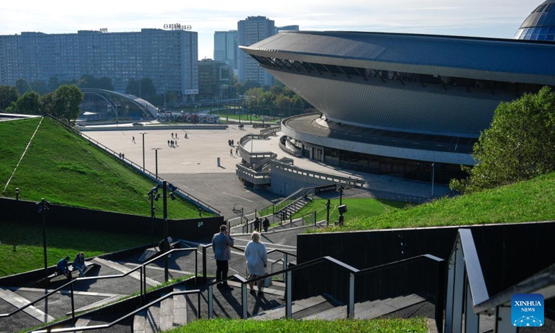 People walk near the Spodek arena, a landmark in Katowice, Poland on Oct. 4, 2025. Katowice, the capital of Poland's Silesian region, once known for its heavy industry, is now revitalizing itself through modern architecture and creative industries. (Photo by Jaap Arriens/Xinhua)