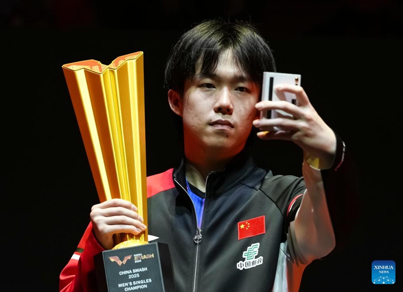 Winner Wang Chuqin of China takes a selfie during the awarding ceremony for the men's singles event at 2025 World Table Tennis (WTT) China Smash in Beijing, China, Oct. 5, 2025. (Xinhua/Sun Fei)