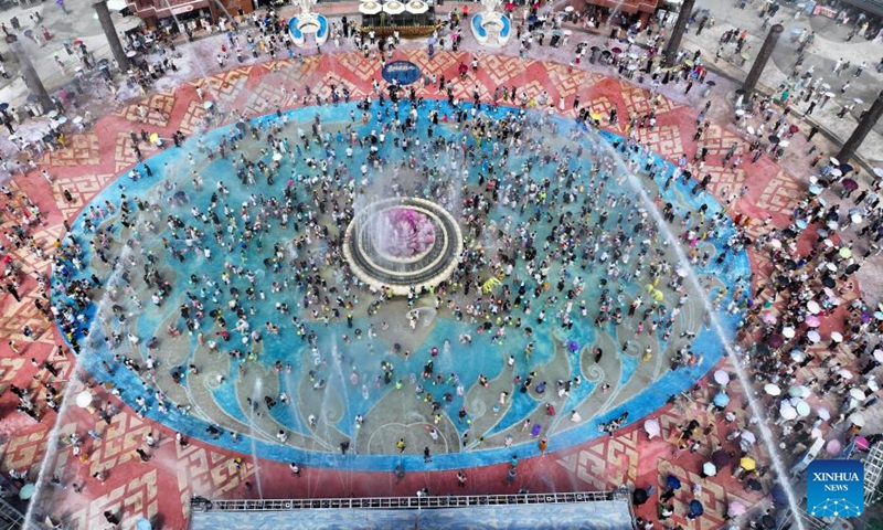 An aerial drone photo taken on Oct. 5, 2025 shows tourists attending a water-splashing event at a scenic spot in Jinghong City, southwest China's Yunnan Province. Tourist destinations across China are witnessing a surge in visitors as the country's eight-day National Day and Mid-Autumn Festival holiday began on Wednesday. Photo: Xinhua