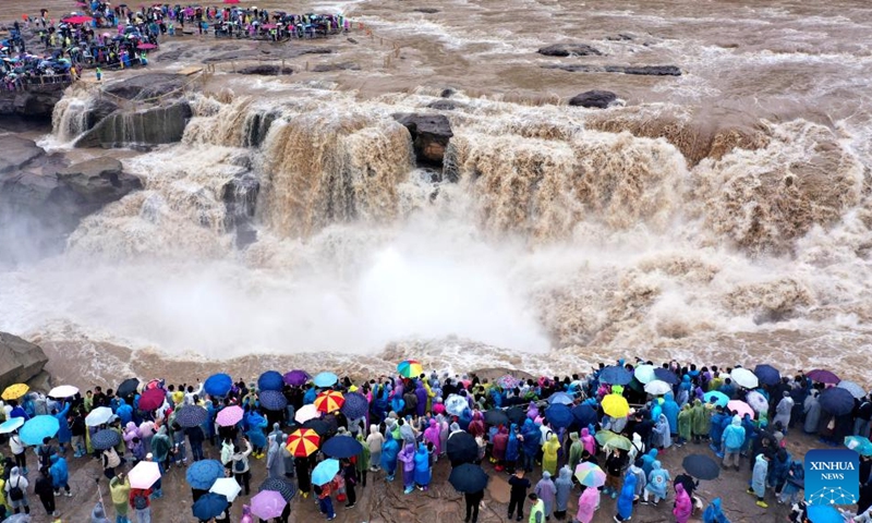An aerial photo taken on Oct. 5, 2025 shows people visiting the Hukou Waterfall on the Yellow River in Jixian County, north China's Shanxi Province. Tourist destinations across China are witnessing a surge in visitors as the country's eight-day National Day and Mid-Autumn Festival holiday began on Wednesday. Photo: Xinhua