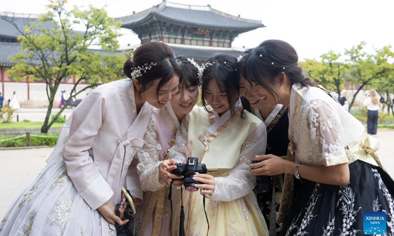 People in traditional Korean attire Hanbok review photos at the Gyeongbokgung Palace in Seoul, South Korea, Oct. 5, 2025. Ancient palaces in Seoul including the Gyeongbokgung Palace are open to the public free of charge from Oct. 3 to 9. (Photo by Jun Hyosang/Xinhua)