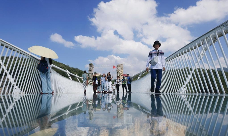 Tourists visit a glass-bottomed bridge at Zhangjiajie Grand Canyon in central China's Hunan Province, Oct. 5, 2025. Tourist destinations across China are witnessing a surge in visitors as the country's eight-day National Day and Mid-Autumn Festival holiday began on Wednesday. Photo: Xinhua