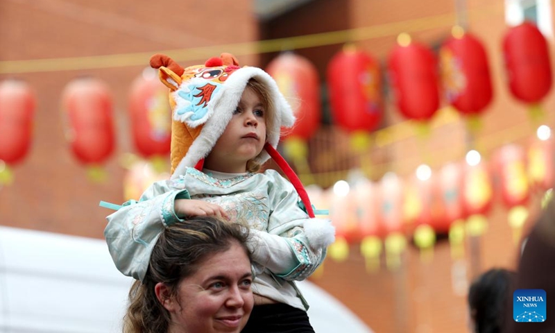 A girl watches a show for the celebration of the Chinese Mid-Autumn Festival in London, Britain, Oct. 5, 2025. A show for the celebration of the Chinese Mid-Autumn Festival was staged in London Chinatown on Sunday afternoon, impressing many with performances featuring Chinese culture and art. (Xinhua/Li Ying)