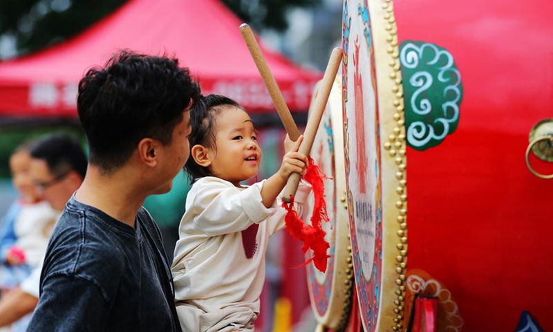 A child plays with a drum in Tengzhou, east China's Shandong Province, Oct. 6, 2025. (Photo by Li Zhijun/Xinhua)