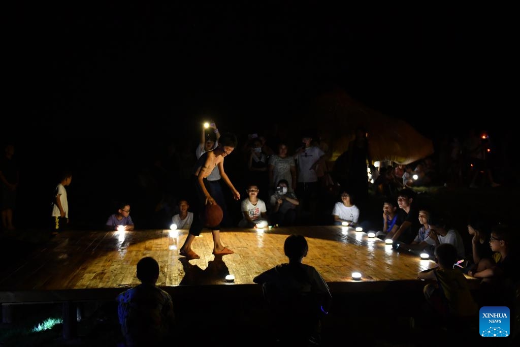 A child performs with a basketball at the Dayuan Center for Community Arts and Culture in Dayuan Village of Ningyuan County, central China's Hunan Province, Aug. 20, 2023. (Xinhua/Chen Zhenhai)