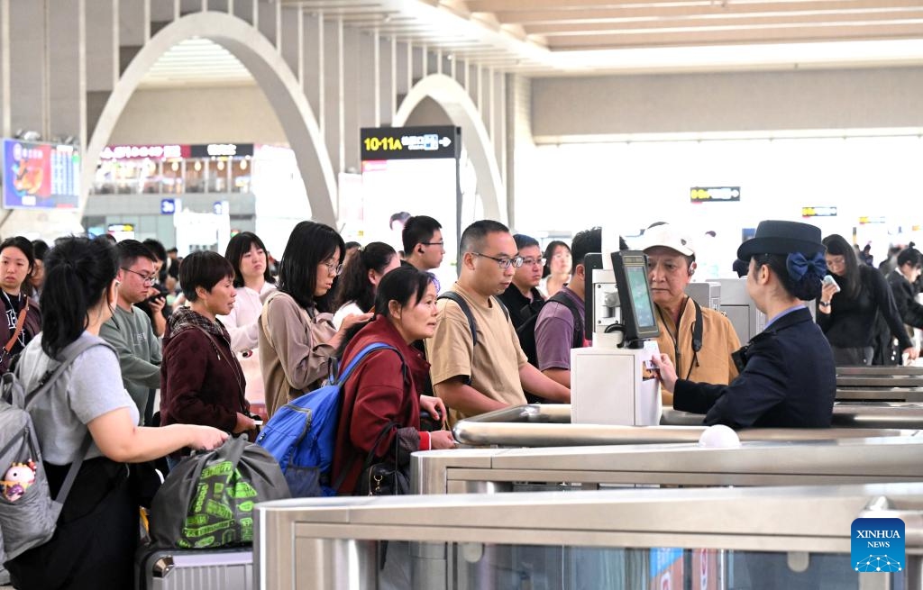 Passengers pass ticket gates at Shijiazhuang Railway Station in Shijiazhuang, north China's Hebei Province, Oct. 7, 2025. As the National Day and Mid-Autumn Festival holiday is drawing to a close, return travel flows increase across the country. (Photo by Chen Qibao/Xinhua)