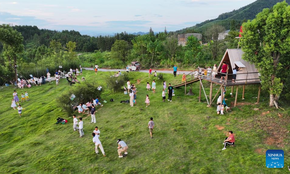 A drone photo taken on Aug. 23, 2025 shows children having fun at the lawn of the Dayuan Center for Community Arts and Culture in Dayuan Village of Ningyuan County, central China's Hunan Province. (Xinhua/Chen Zhenhai)