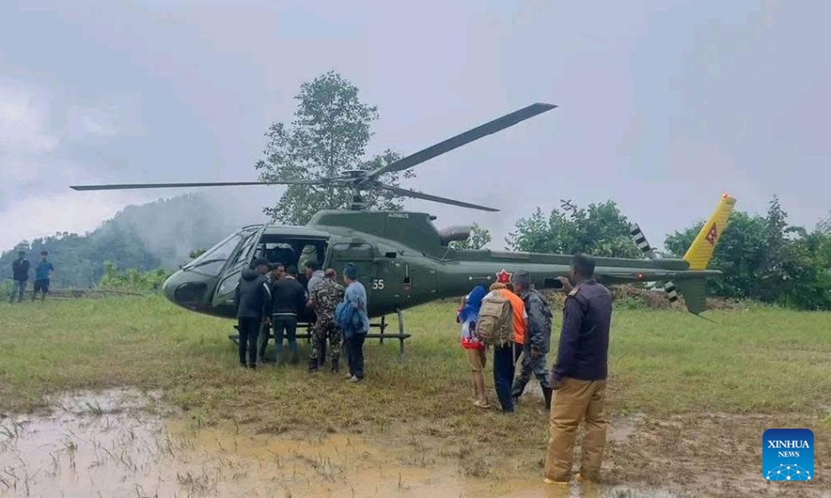 Rescuers transfer a pregnant woman by a helicopter in Ilam district, Nepal, on Oct. 6, 2025. (Nepal Army/Handout via Xinhua)