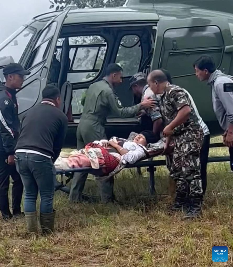 Rescuers transfer a pregnant woman by a helicopter in Ilam district, Nepal, on Oct. 6, 2025. (Nepal Army/Handout via Xinhua)