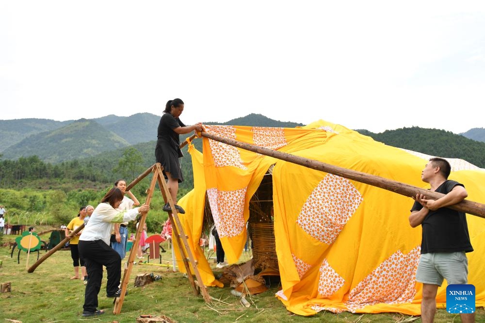 Zhou Yan (L, up), volunteers and villagers set up an artistic house in Dayuan Village of Ningyuan County, central China's Hunan Province, Aug. 20, 2023. (Xinhua/Chen Zhenhai)