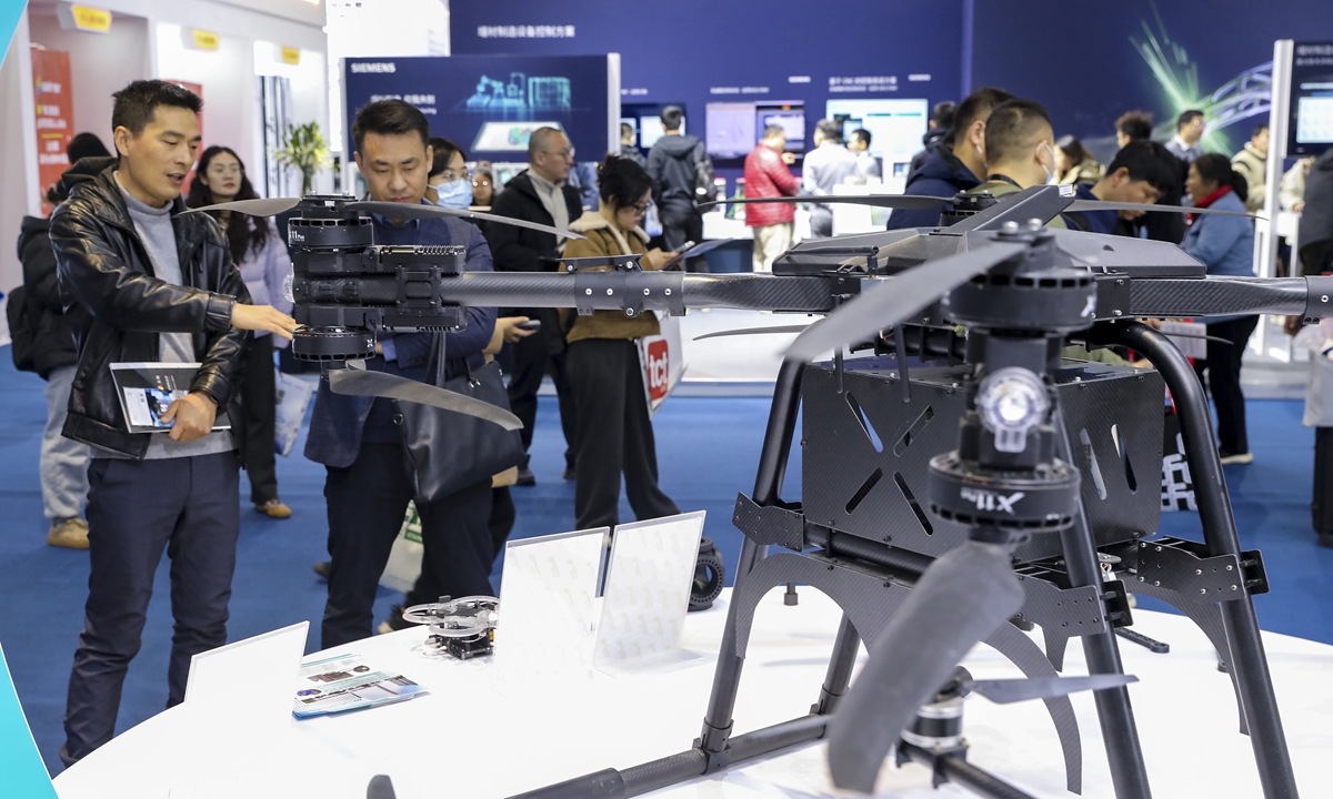 Visitors look at a drone at an exhibition in Shanghai on March 18, 2025. Photo:VCG