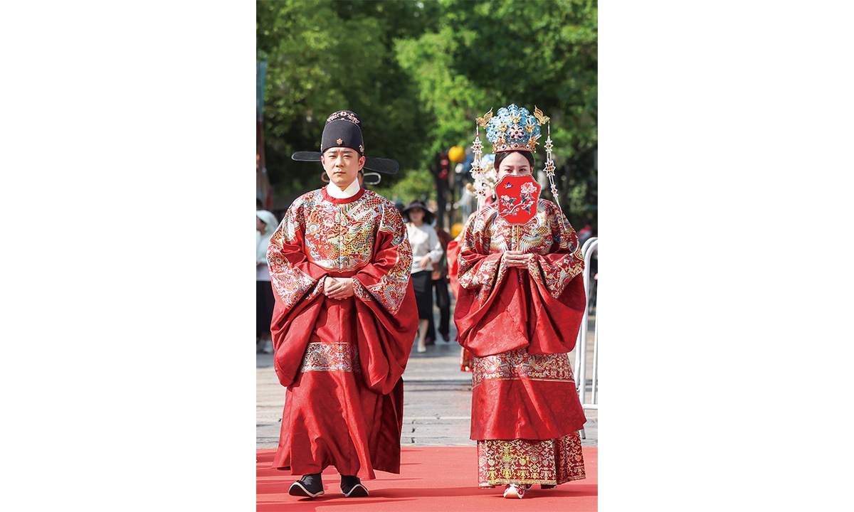 A newlywed couple dressed in splendid traditional attire takes part in a group wedding ceremony in Nanjing, the capital of East China's Jiangsu Province, on May 29, 2025.