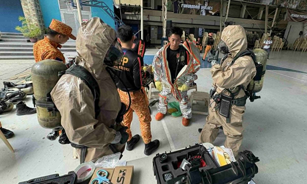 Firefighters wear protective suits as they respond to a chemical spill incident at San Pedro College following a strong earthquake in Davao City, southern Philippines on October 10, 2025. Photo: VCG