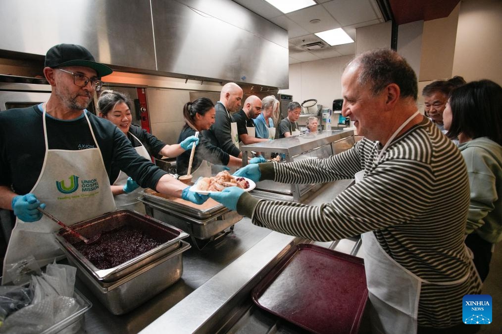 Volunteers dispense Thanksgiving meals inside a kitchen at the Union Gospel Mission in Vancouver, British Columbia, Canada, Oct. 10, 2025. The local charity served about 2,000 free meals on Friday to the local residents suffering from unemployment, rising living costs and a lack of affordable housing as part of an early Thanksgiving celebration. Canada's Thanksgiving Day falls on Oct. 13 this year. (Photo: Xinhua)