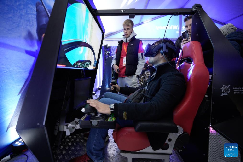 People try a virtual flight simulator during an aviation night event in Warsaw, Poland, Oct. 10, 2025. (Photo: Xinhua)
