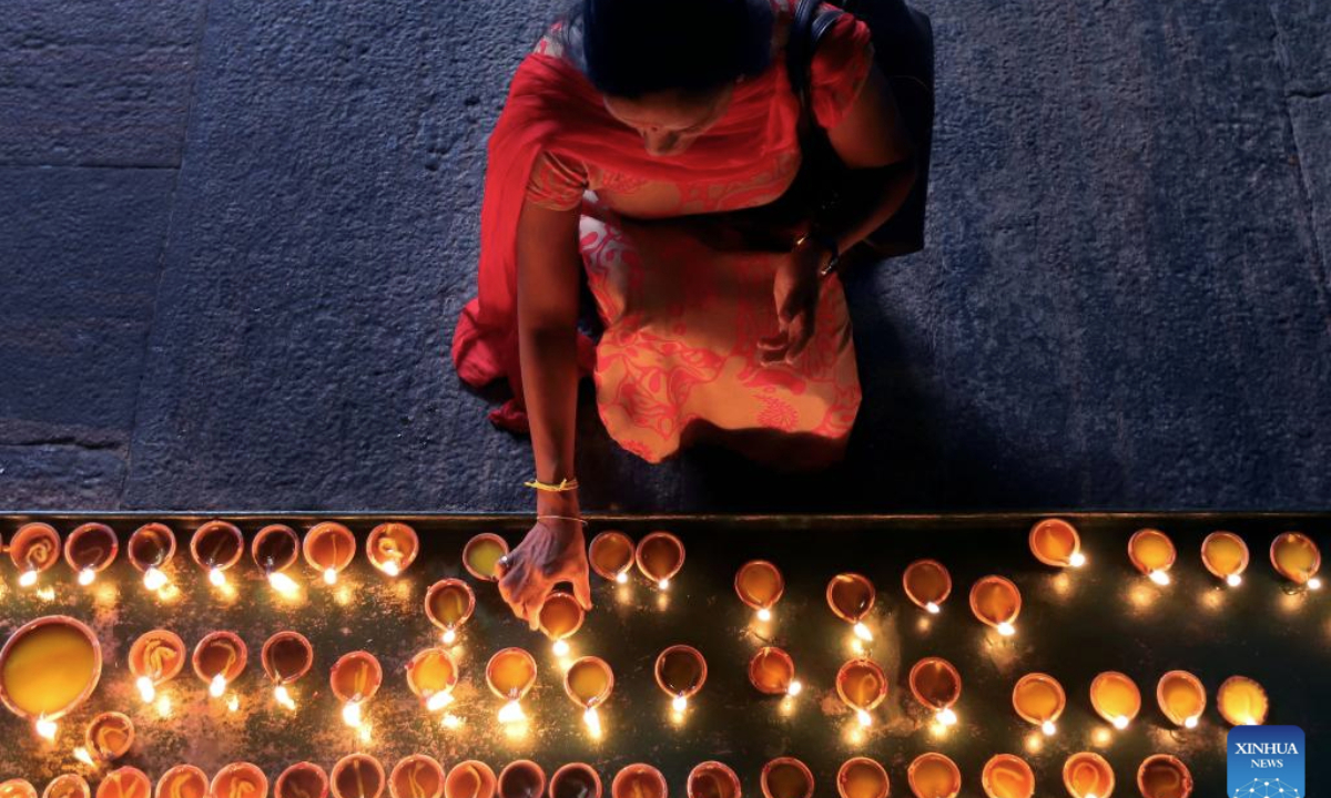 A woman lights oil lamps to celebrate Diwali, or the Hindu festival of lights, at a temple in Colombo, Sri Lanka, on Oct. 20, 2025. (Photo by Ajith Perera/Xinhua)