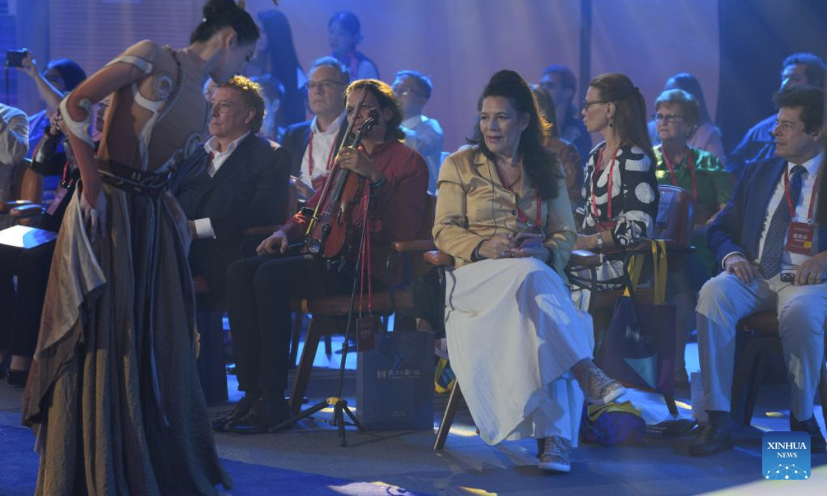 Guests watch a performance staged by a song and dance troupe during the World Poetry, Dance, Music and Visual Arts Salon in Hangzhou, east China's Zhejiang Province, Oct. 18, 2025. The World Poetry, Dance, Music and Visual Arts Salon was held here on Saturday as a sideline event of the third Liangzhu Forum. The salon features performances and civilization dialogues, with the participation of more than 20 international artists and cultural scholars. (Xinhua/Huang Zongzhi)