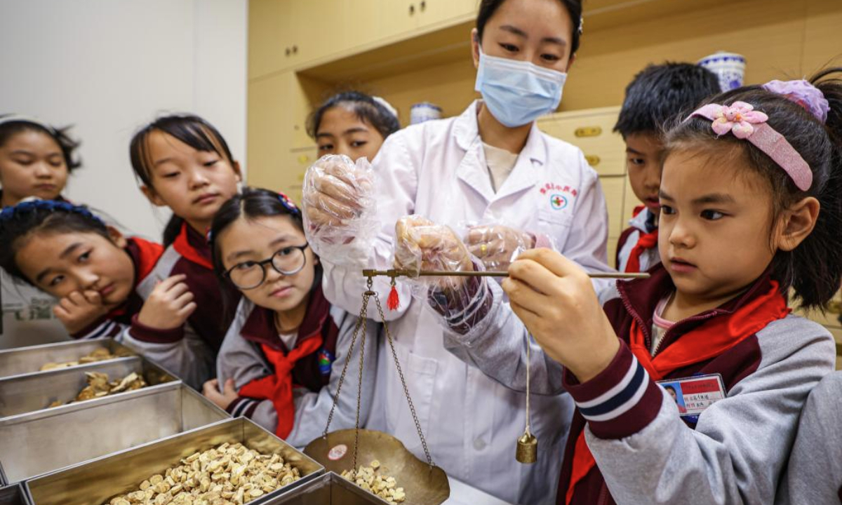 Students learn to measure herbs of traditional Chinese medicine (TCM) at a hospital in Rongcheng City, east China's Shandong Province, Oct. 22, 2025. Lessons on TCM were introduced in various ways across the country to welcome the annual World Traditional Medicine Day which falls on Oct. 22. (Photo by Li Xinjun/Xinhua)